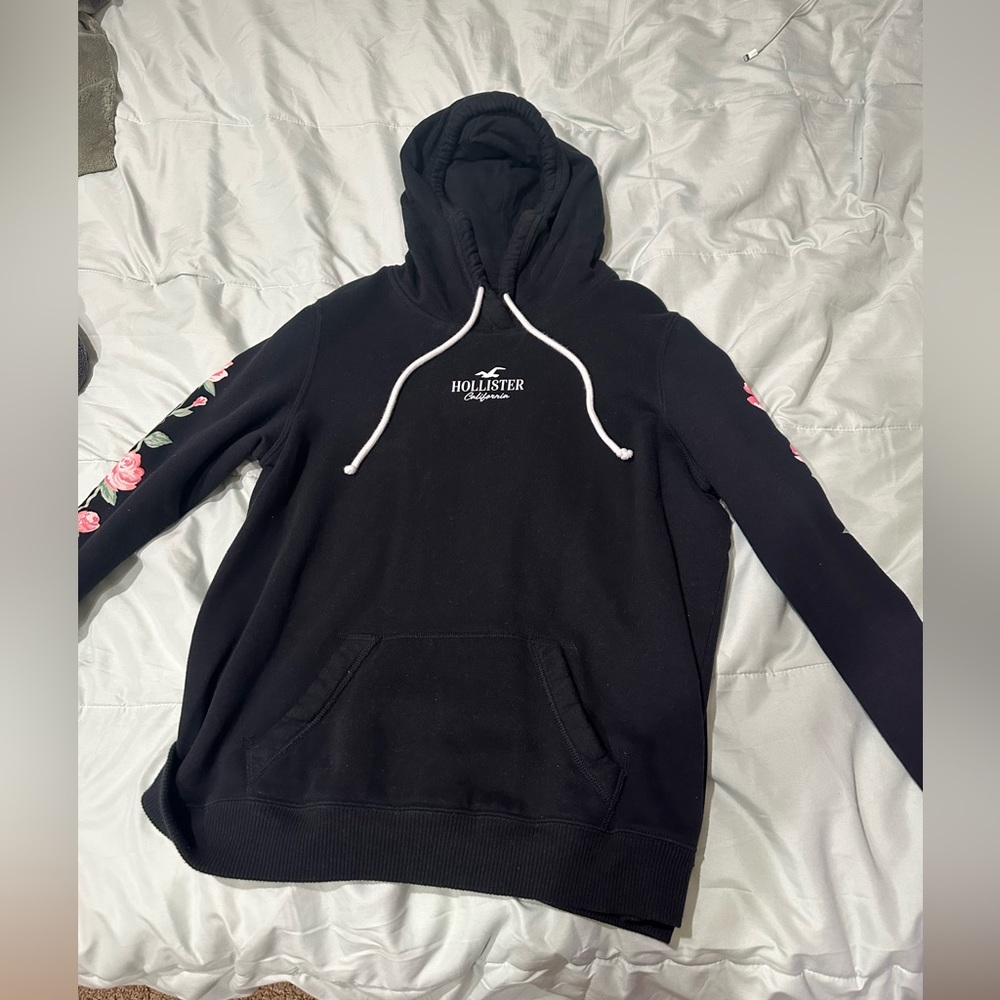 Black Hollister hoodie with flower details along the sleeves